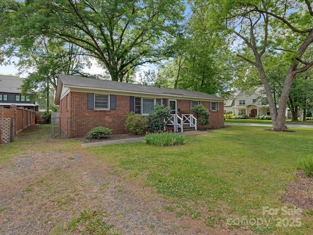 single story home featuring a front lawn, brick siding, and fence