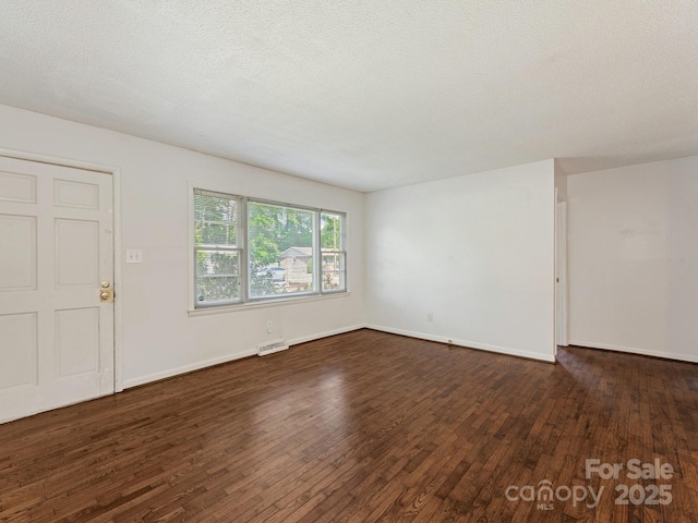 unfurnished living room with baseboards, visible vents, and wood finished floors