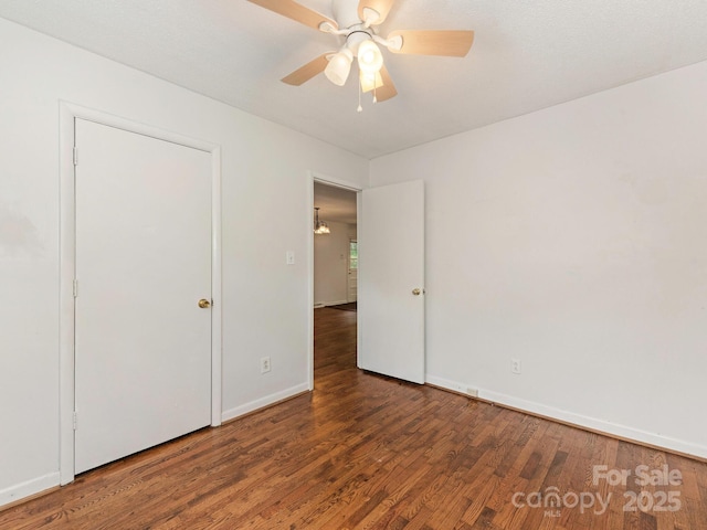 unfurnished bedroom with a ceiling fan, wood finished floors, and baseboards