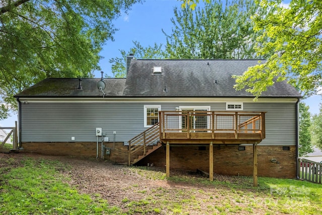 back of property with a deck, stairway, a chimney, and roof with shingles