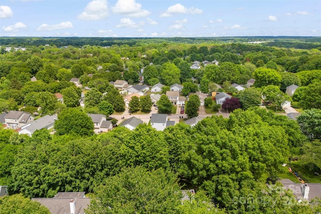 aerial perspective of suburban area featuring a heavily wooded area