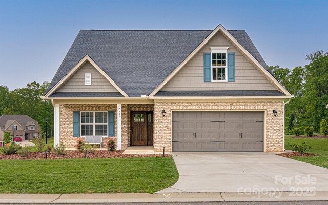 craftsman house featuring concrete driveway, a garage, roof with shingles, and a front lawn