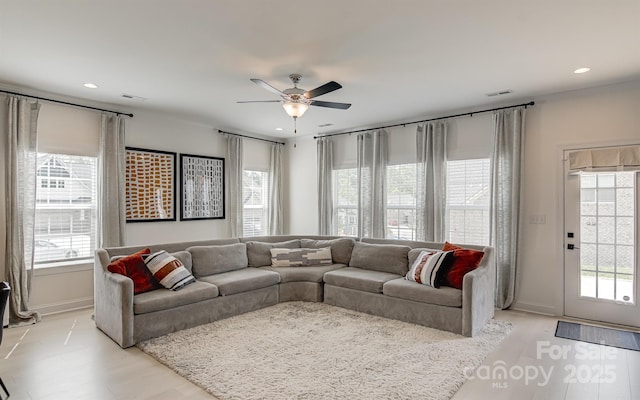 living room with recessed lighting, ceiling fan, plenty of natural light, and baseboards