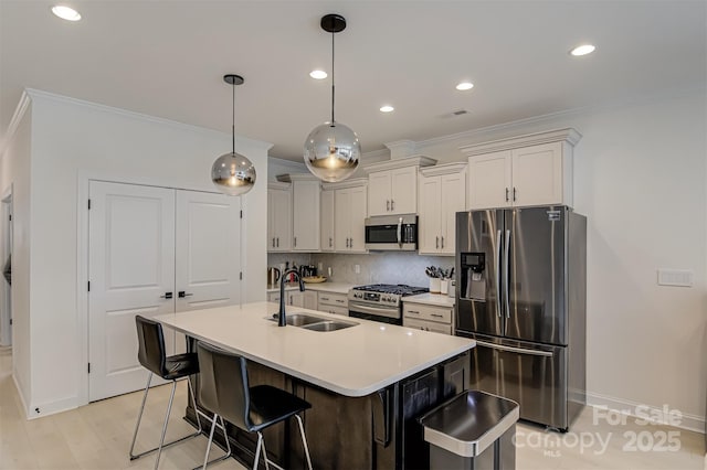 kitchen with a sink, tasteful backsplash, ornamental molding, and stainless steel appliances