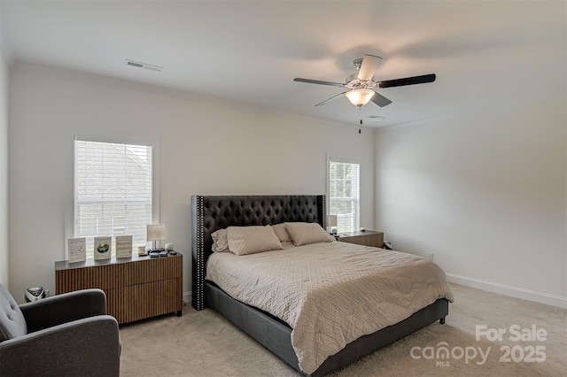 bedroom with light colored carpet, a ceiling fan, visible vents, and baseboards