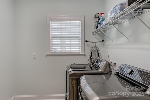 laundry room with a healthy amount of sunlight, baseboards, laundry area, and washing machine and clothes dryer