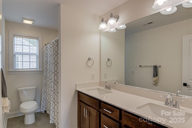 full bathroom featuring a sink, tile patterned flooring, toilet, and double vanity