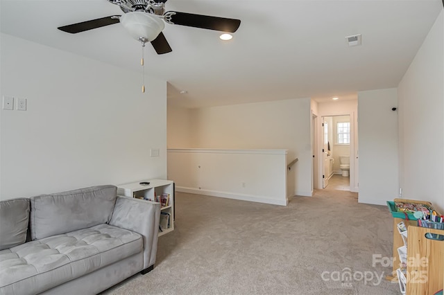 sitting room featuring ceiling fan, carpet floors, baseboards, an upstairs landing, and visible vents