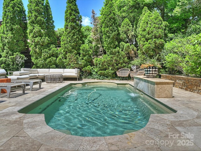 swimming pool with a patio and an outdoor hangout area