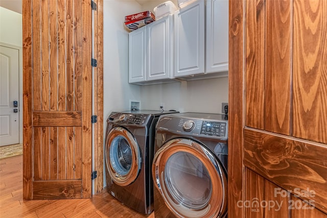 laundry area featuring cabinet space, independent washer and dryer, and wood finished floors