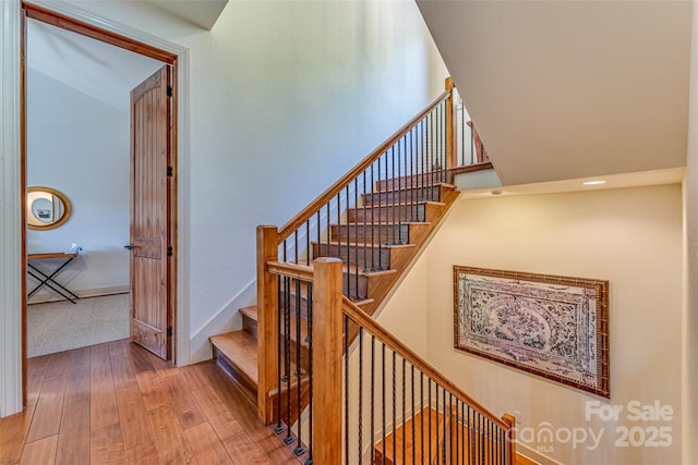 stairs featuring hardwood / wood-style floors
