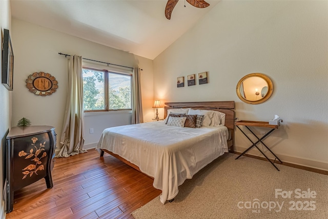 bedroom with baseboards, wood finished floors, and lofted ceiling