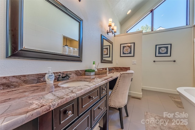 full bath featuring vanity, lofted ceiling, baseboards, and tile patterned floors