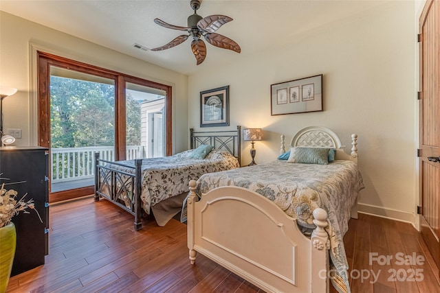 bedroom featuring access to outside, dark wood-type flooring, visible vents, ceiling fan, and baseboards