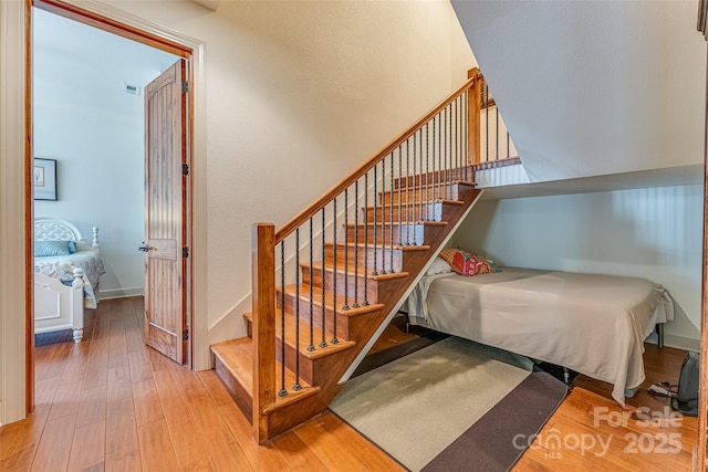 staircase featuring visible vents and wood-type flooring