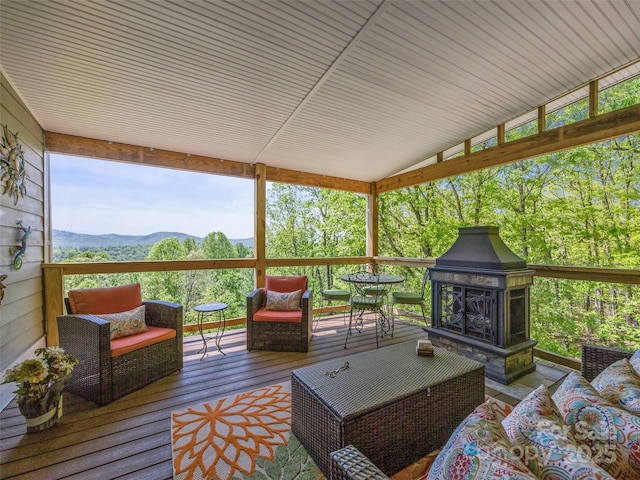 wooden terrace with an outdoor living space with a fireplace and a mountain view