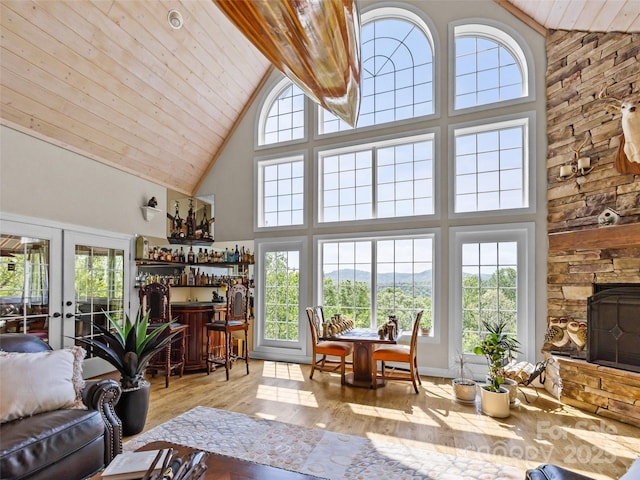 living room with wood finished floors, french doors, high vaulted ceiling, wood ceiling, and a bar