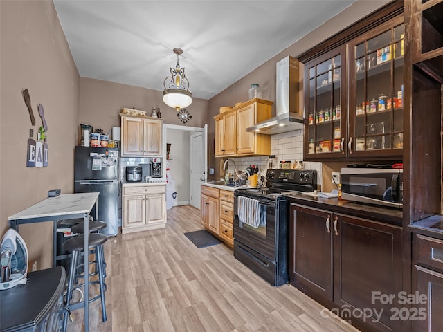 kitchen with appliances with stainless steel finishes, light wood-style floors, decorative backsplash, range hood, and glass insert cabinets