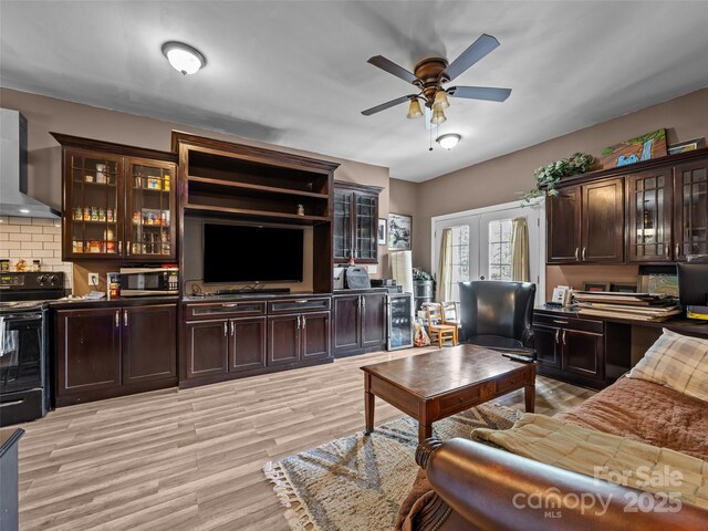 living room with french doors, ceiling fan, and light wood-style flooring