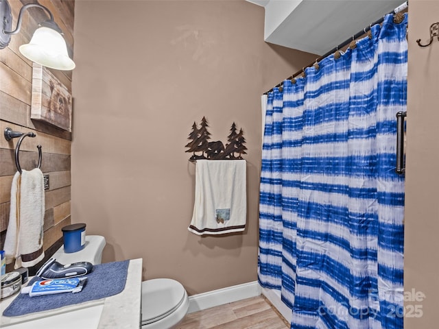 full bath featuring baseboards, a shower with shower curtain, wood finished floors, and toilet