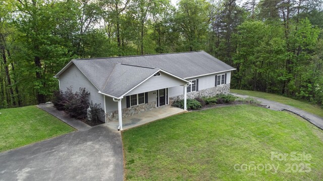 single story home with a shingled roof, a front yard, a porch, and stone siding