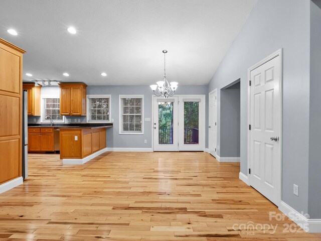 kitchen featuring an inviting chandelier, dark countertops, baseboards, recessed lighting, and light wood-style flooring