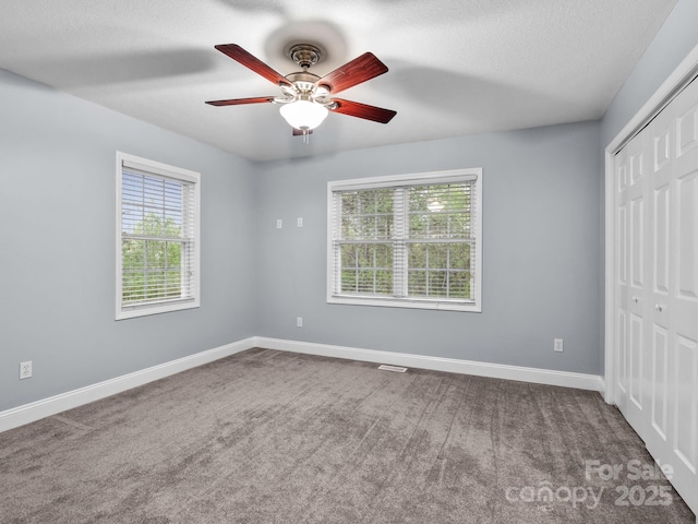 unfurnished bedroom with a ceiling fan, baseboards, carpet, and a closet