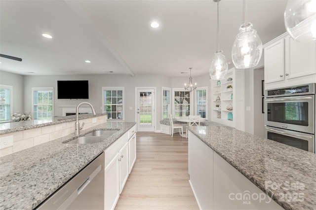 kitchen with stainless steel appliances, recessed lighting, a sink, and light wood finished floors