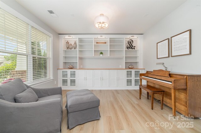 sitting room with light wood-style floors and visible vents