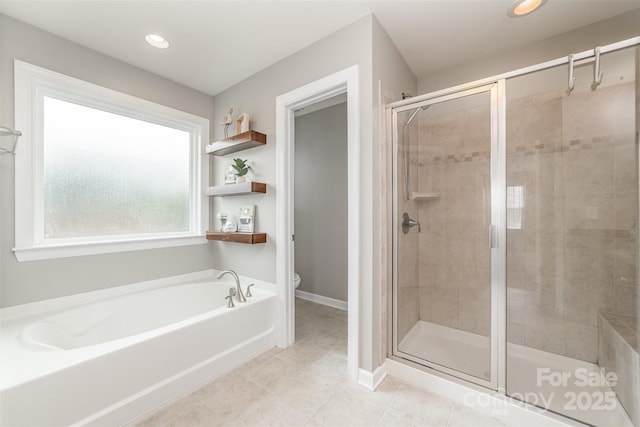 full bathroom featuring toilet, tile patterned floors, baseboards, a bath, and a stall shower
