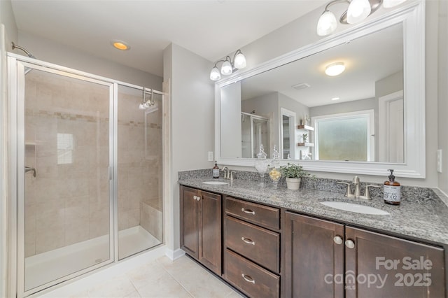 full bath featuring a sink, tile patterned flooring, a shower stall, and double vanity