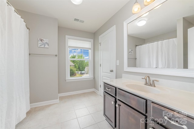 bathroom with baseboards, vanity, tile patterned floors, and visible vents