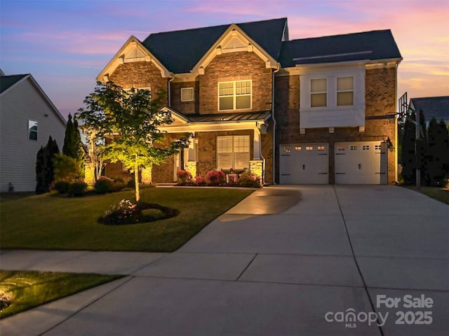 view of front facade with a lawn, a garage, stone siding, and concrete driveway