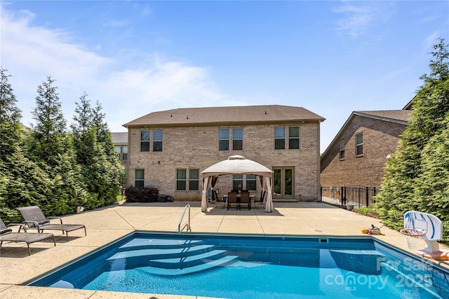 pool with a gazebo, fence, and a patio