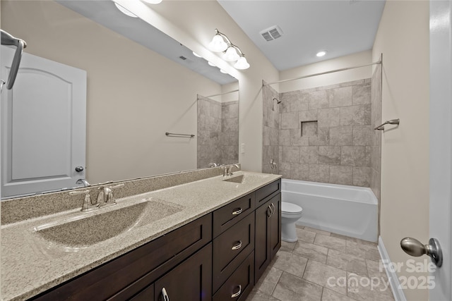 bathroom with double vanity, toilet, visible vents, and a sink