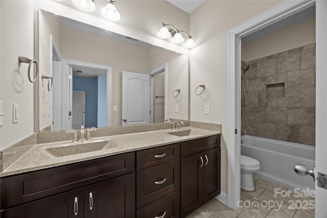 bathroom featuring double vanity, a sink, visible vents, and toilet