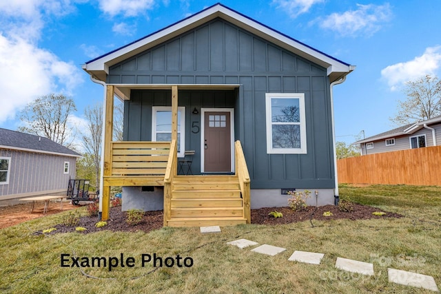 4 Chestnut Ridge Ave, Asheville, NC 28804 - bungalow featuring board and batten siding, crawl space, fence, and a front lawn