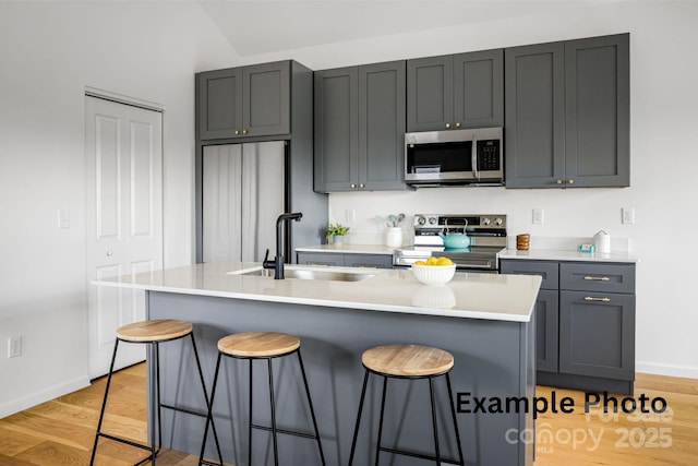 4 Chestnut Ridge Ave, Asheville, NC 28804 - kitchen with a breakfast bar, a sink, stainless steel appliances, baseboards, and light wood-type flooring
