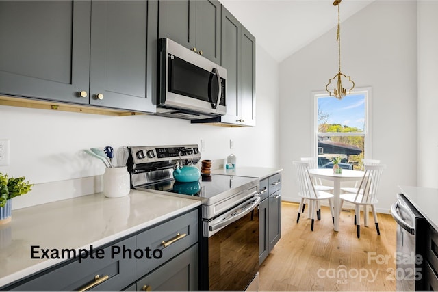 4 Chestnut Ridge Ave, Asheville, NC 28804 - kitchen featuring appliances with stainless steel finishes, hanging light fixtures, light wood-type flooring, light countertops, and a notable chandelier