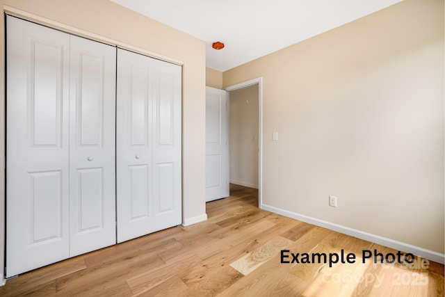 4 Chestnut Ridge Ave, Asheville, NC 28804 - unfurnished bedroom featuring baseboards, a closet, and light wood-type flooring