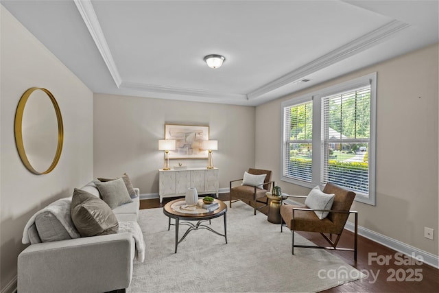 living room with baseboards, visible vents, wood finished floors, and a raised ceiling