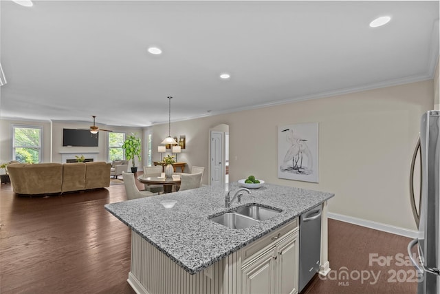 kitchen with a kitchen island with sink, appliances with stainless steel finishes, dark wood finished floors, a sink, and open floor plan