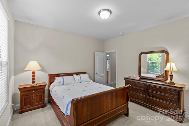 bedroom with baseboards and light colored carpet