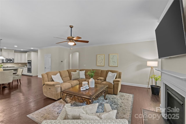 907 Lingfield Ln, Waxhaw, NC 28173 - living area featuring a fireplace with flush hearth, a ceiling fan, ornamental molding, recessed lighting, and dark wood-style flooring