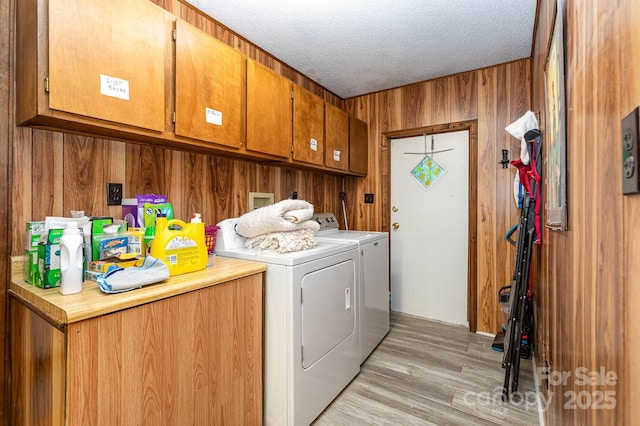 6804 Lineberger Rd, Denver, NC 28037 - laundry area with cabinet space, washing machine and dryer, wood walls, a textured ceiling, and light wood-style flooring