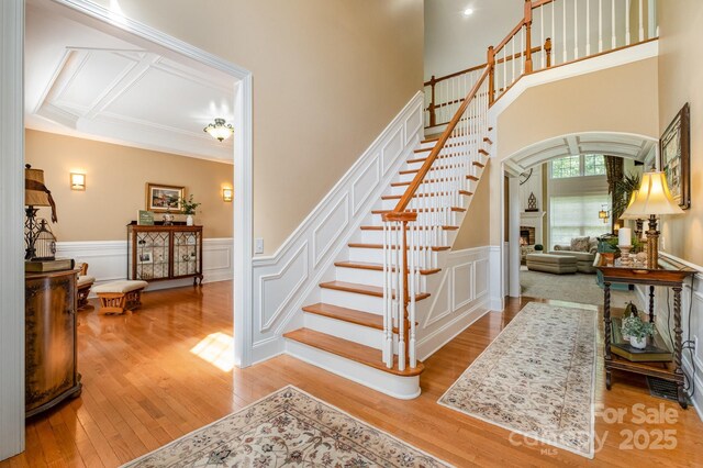 7730 Windsor Forest Pl, Harrisburg, NC 28075 - stairway with wood finished floors, a fireplace, and arched walkways