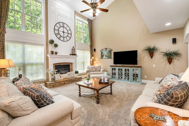 7730 Windsor Forest Pl, Harrisburg, NC 28075 - carpeted living room with a fireplace, baseboards, high vaulted ceiling, and a ceiling fan