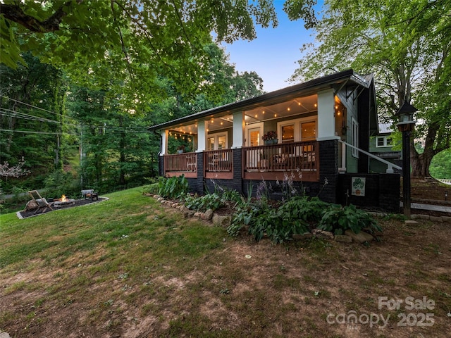 68 Piney Mountain Church Rd, Candler, NC 28715 - back of property with an outdoor fire pit, a wooden deck, and a yard