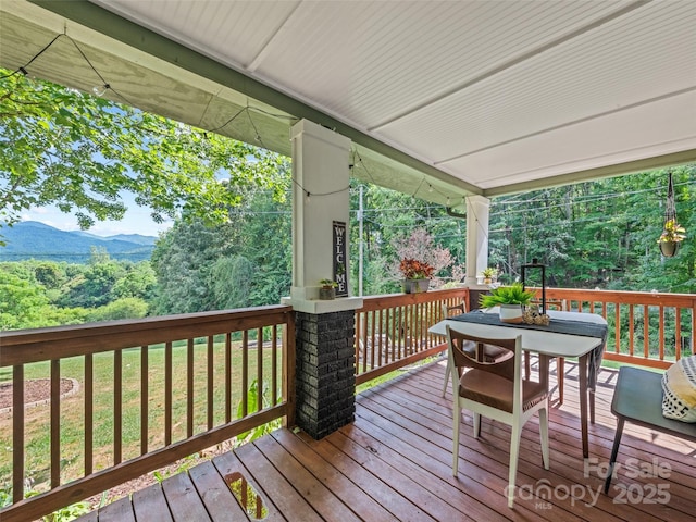 68 Piney Mountain Church Rd, Candler, NC 28715 - wooden terrace with outdoor dining area, a lawn, and a mountain view