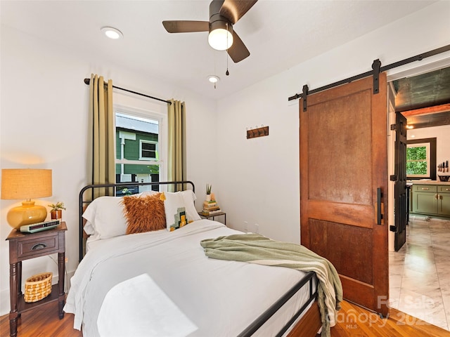 68 Piney Mountain Church Rd, Candler, NC 28715 - bedroom featuring a ceiling fan, light wood finished floors, and a barn door